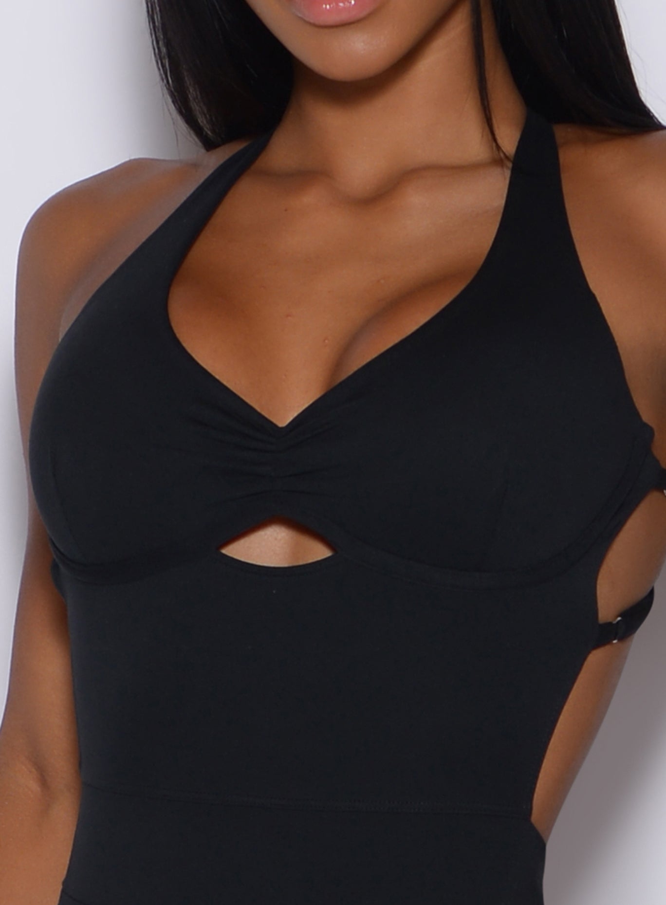 Picture of a model showing her cleavage and wearing a black bodysuit 