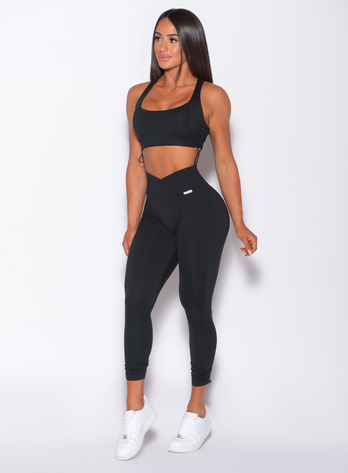 Front profile view of a model in our black toggle leggings and a matching bra 