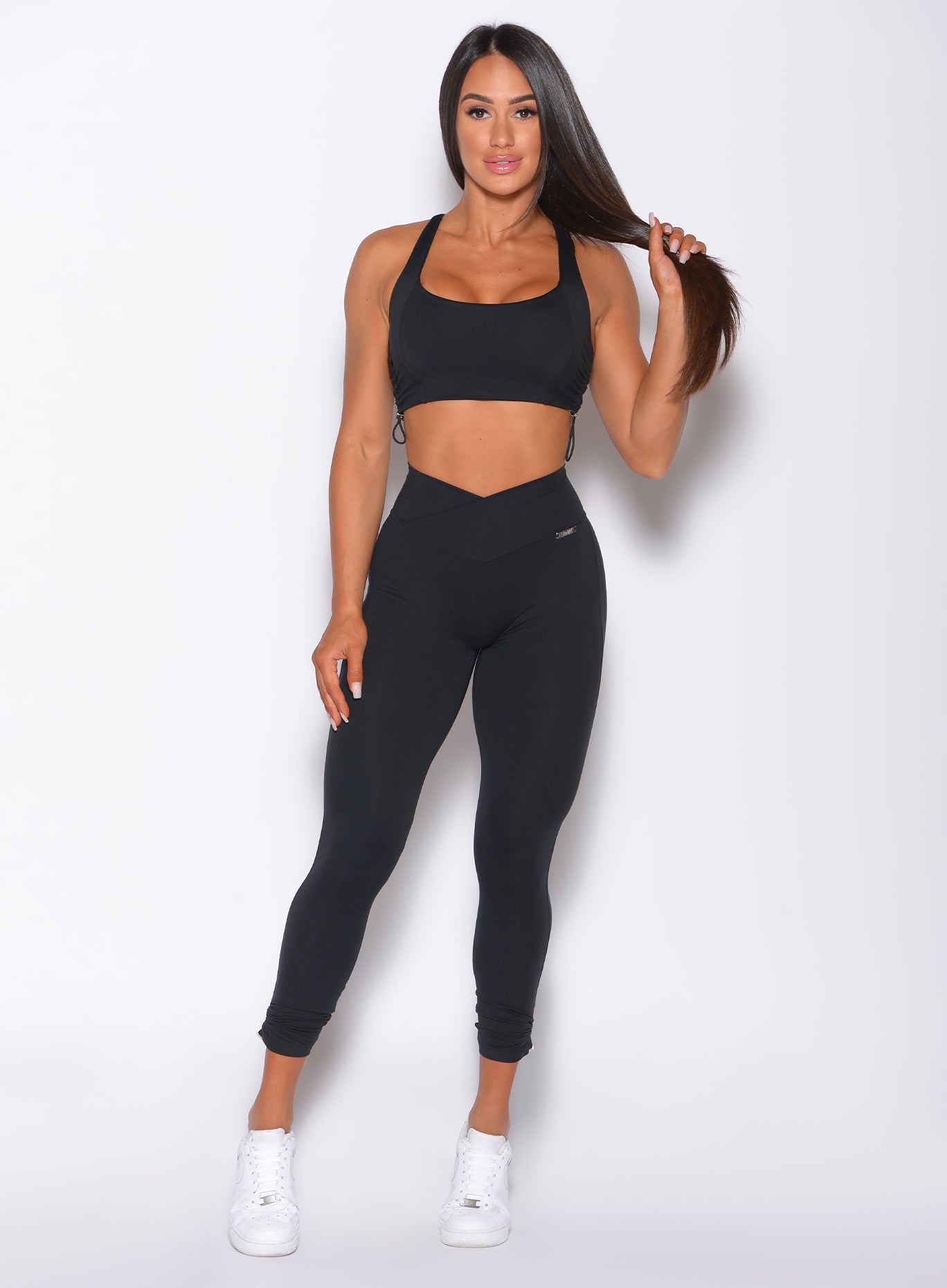 Front profile view of a model wearing our toggle leggings and a matching sports bra 