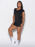 front profile picture of a model wearing our black Open Back Tee Bodysuit Short
