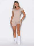 front profile view of a model wearing our Open Back Tee Bodysuit Short in nude color 