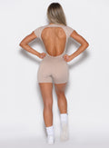 back profile view of a model wearing our Open Back Tee Bodysuit Short in nude color 