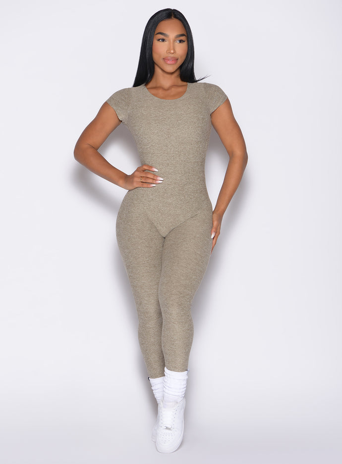 front profile view of a model with one hand on her waist wearing the Open Back Tee Bodysuit in Toasted Sugar color