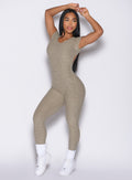 front profile view of a model holding both her hands on top of her head wearing the Open Back Tee Bodysuit in Toasted Sugar color