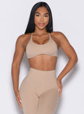 front profile view of a model wearing the Passion Sports Bra in glacial beige color
