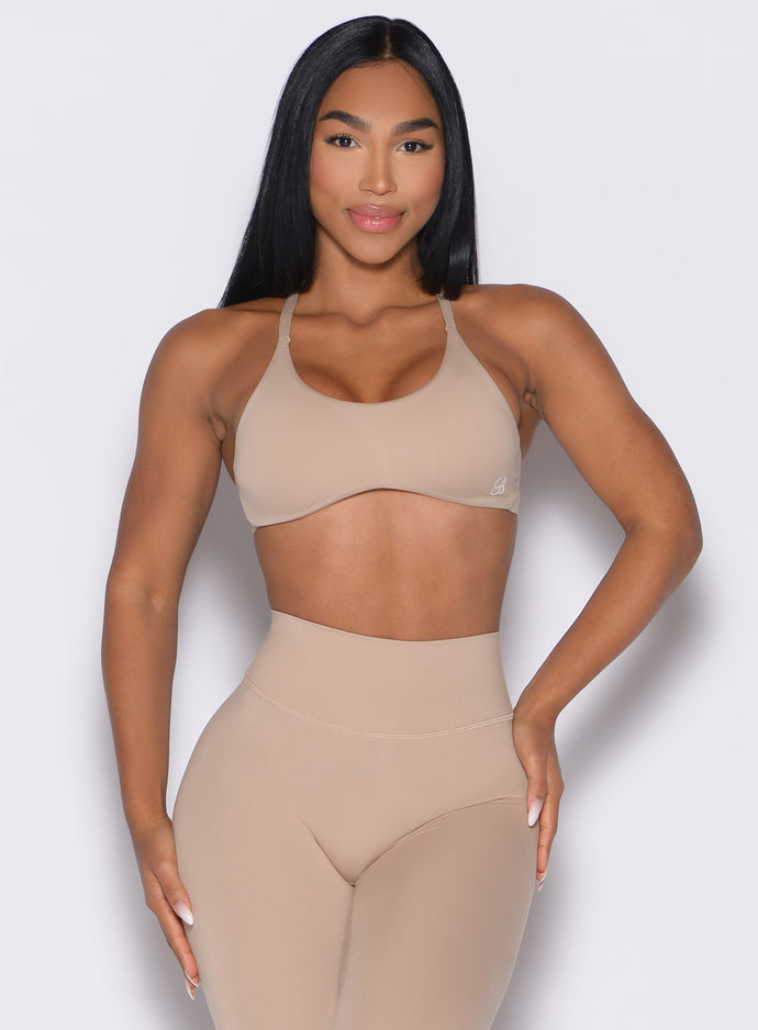 front profile view of a model wearing the Passion Sports Bra in glacial beige color