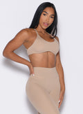front right side profile view of a model with one hand on her waist wearing the Passion Sports Bra in glacial beige color