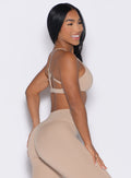 right side profile view of a model wearing the Passion Sports Bra in glacial beige color