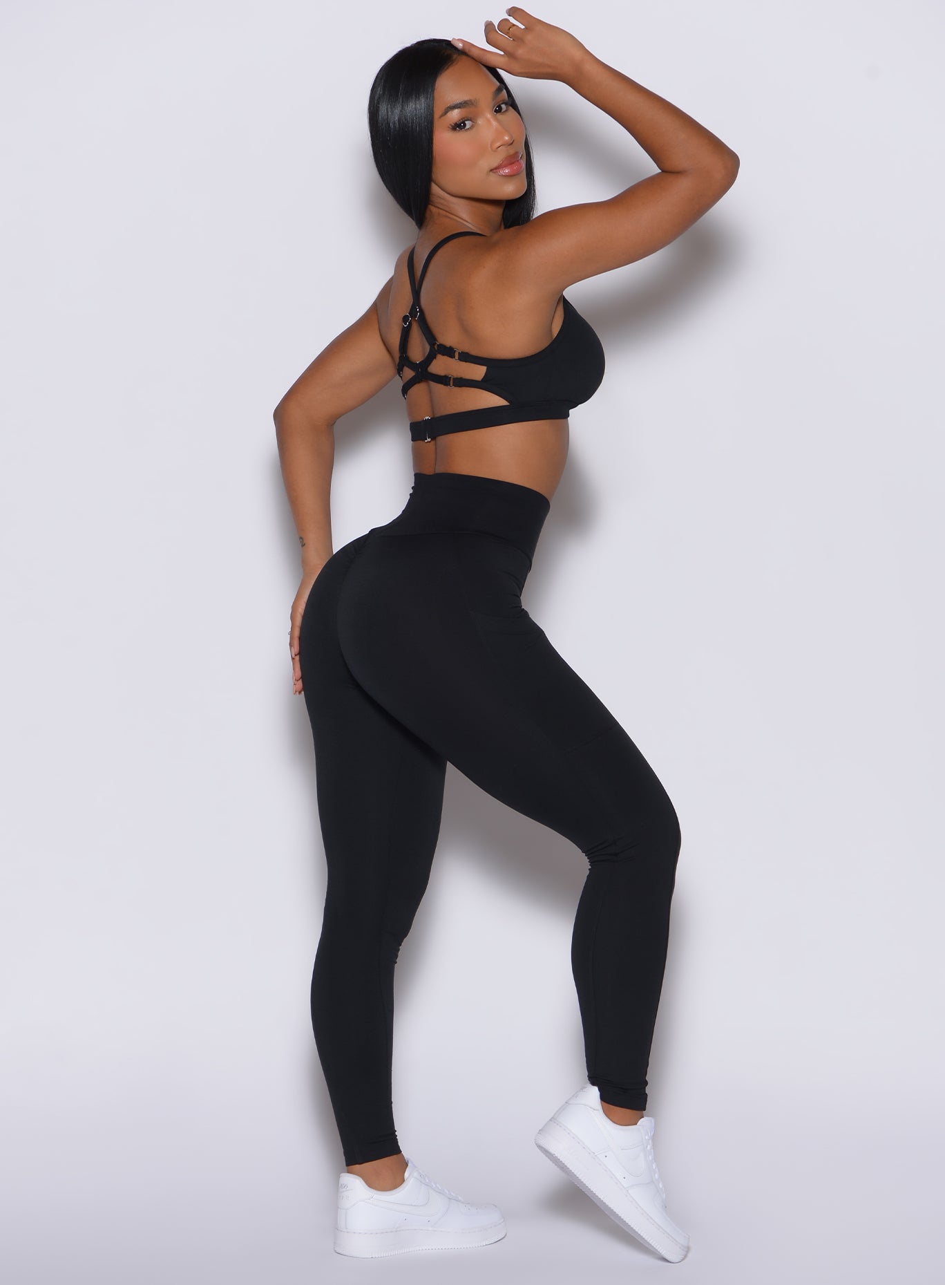Right side profile view of a model wearing our black peach pocket leggings along with a matching bra
