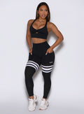 left side profile view of the model wearing our black perform thigh high leggings and a matching bralette 