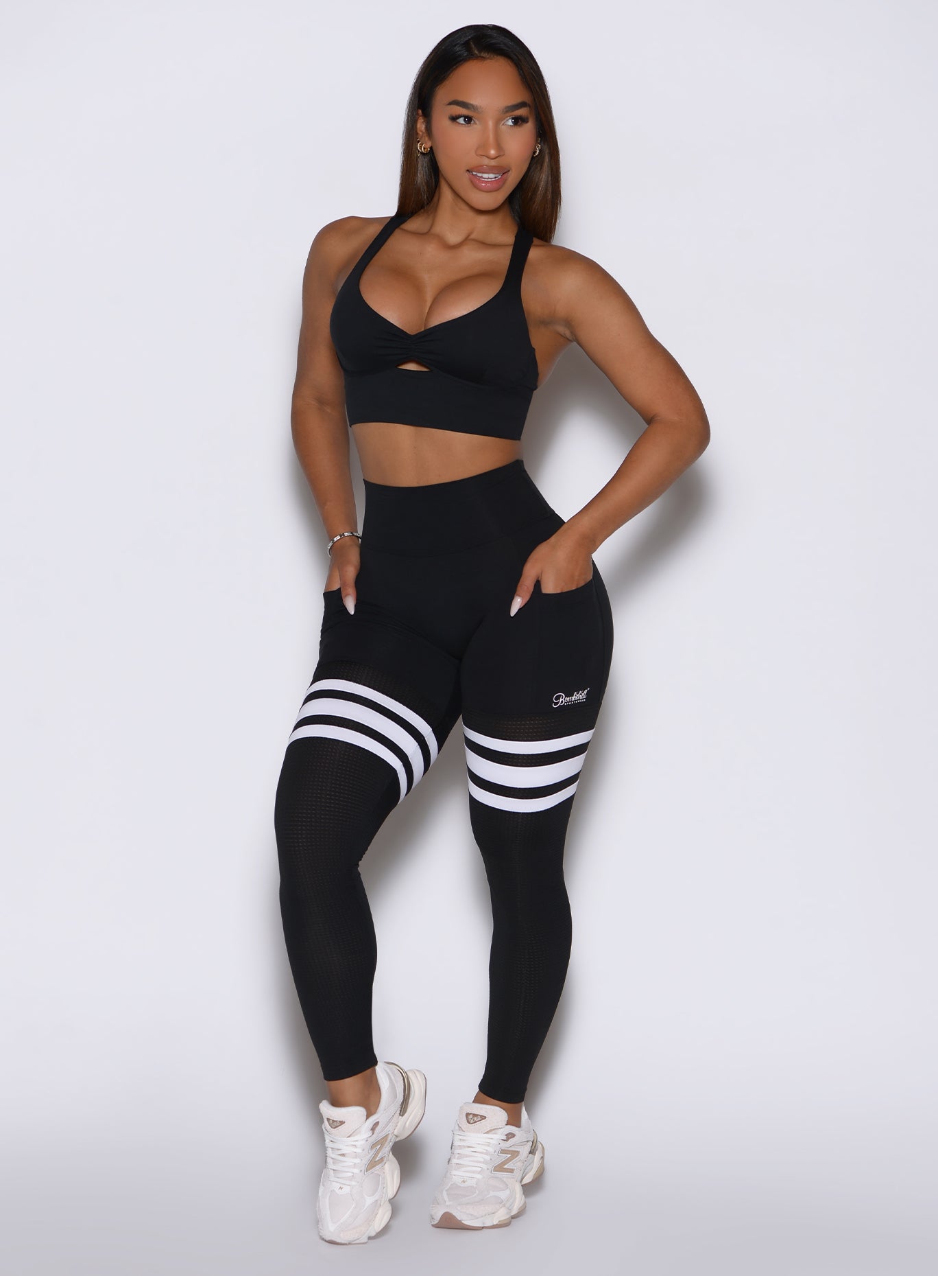 left side profile view of the model wearing our black perform thigh high leggings and a matching bralette 