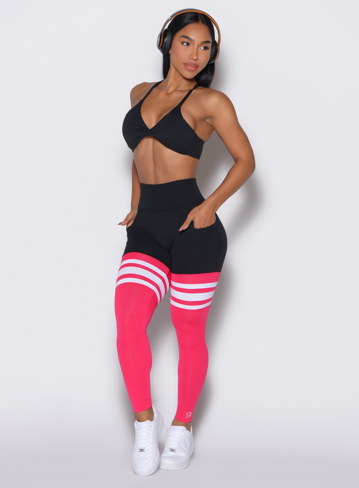 Front left side profile view of a model facing left wearing the Perform Thigh Highs in Black Sky color along with a black sports bra