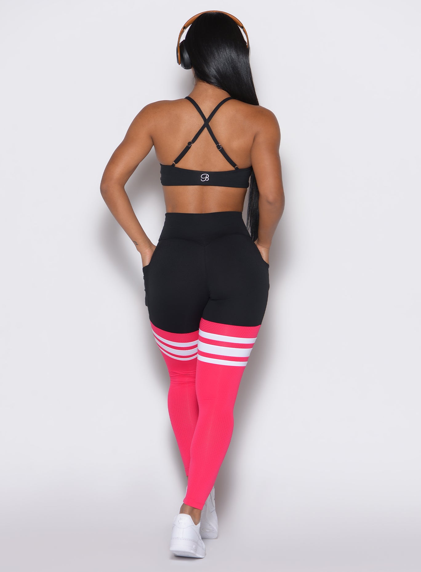 Back profile view of a model wearing the Perform Thigh Highs in Black Sky color  along with a black sports bra
