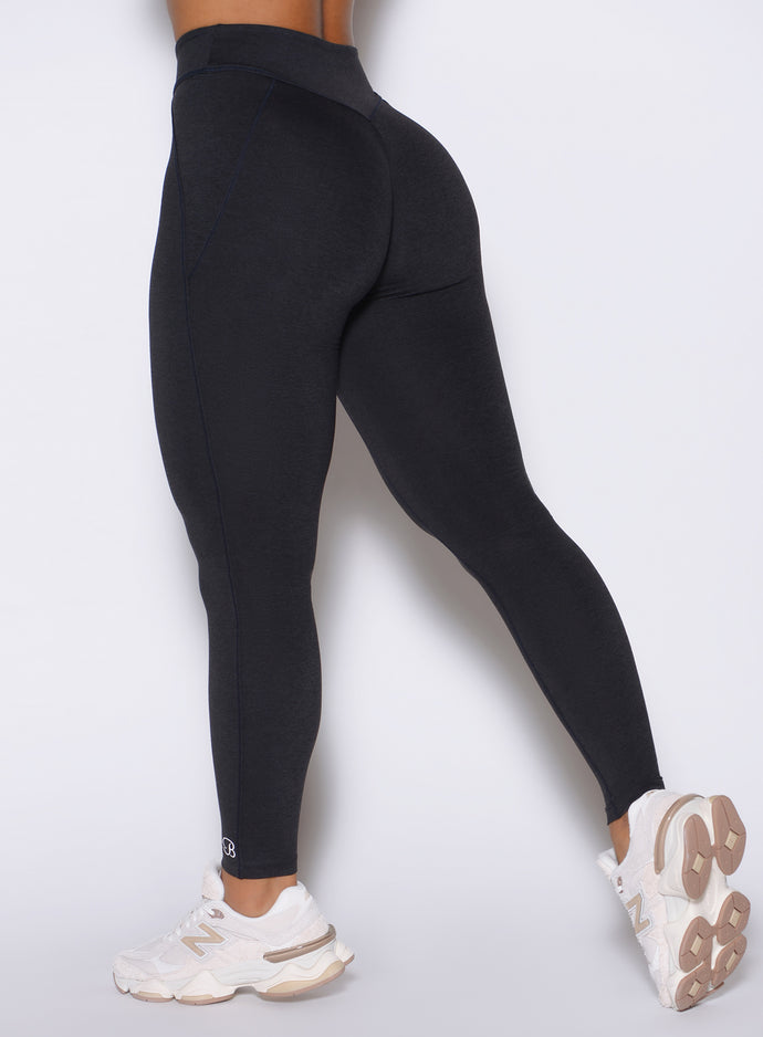Detailed close up back left side shot of the model wearing our Physique leggings in Heathered Black color.