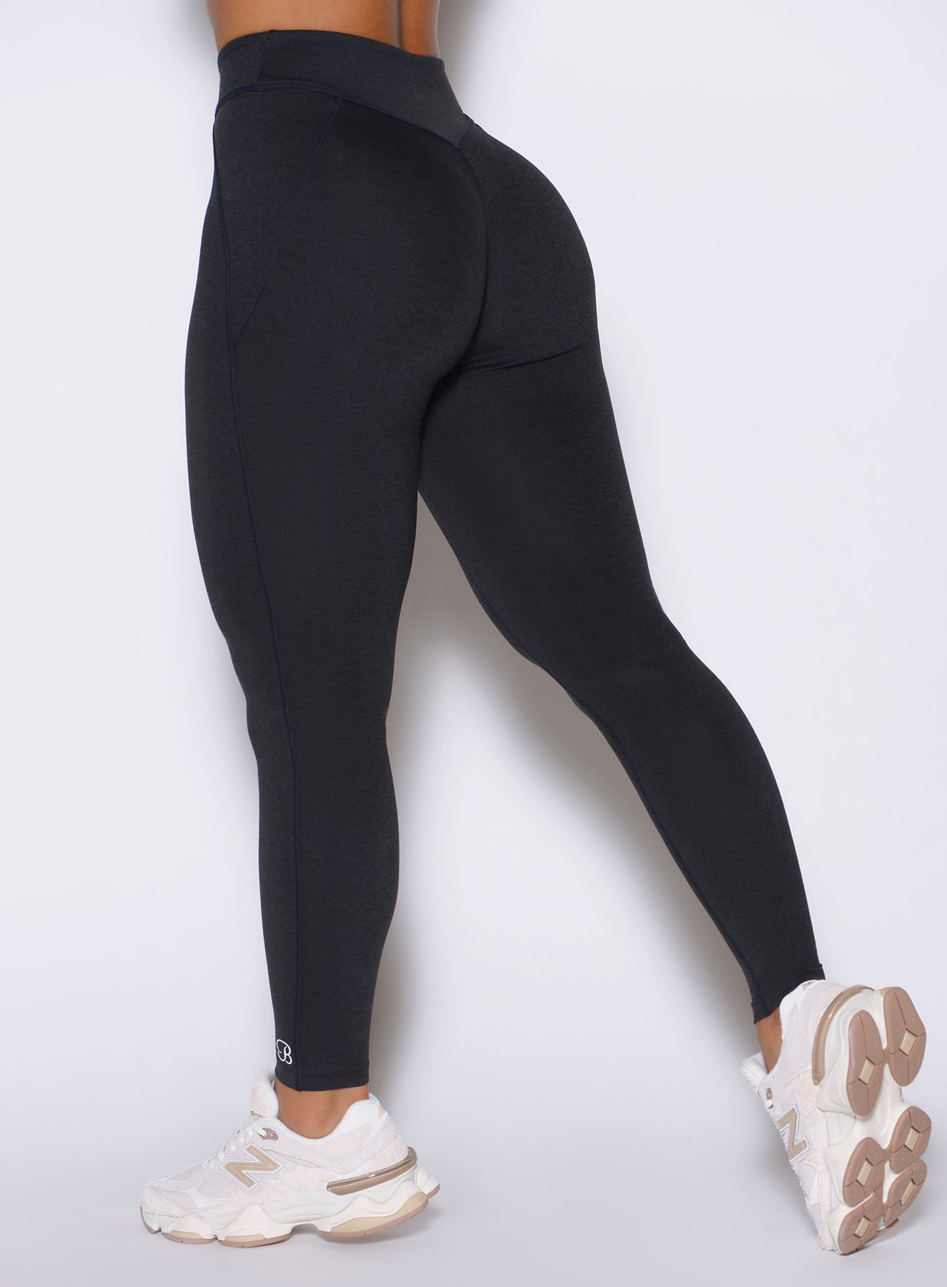 Detailed close up back left side shot of the model wearing our Physique leggings in Heathered Black color.