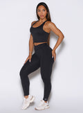 Front left side profile view of the model wearing our Physique leggings in Heathered Black color.