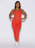 Front profile view of the model wearing our Physique leggings in Inferno color, paired with the matching top.