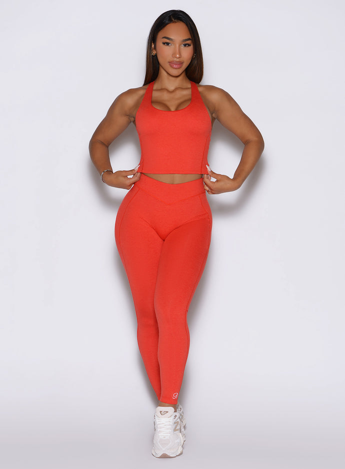 Front profile view of the model wearing our Physique leggings in Inferno color, paired with the matching top.
