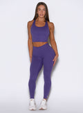 Front profile view of the model wearing our Physique leggings in Iris color.