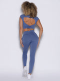 back profile view of a model wearing the PocketBoost Leggings in Blue Slate color