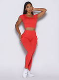 front profile view of a model wearing the PocketBoost Leggings in Command red color paired with the matching tee