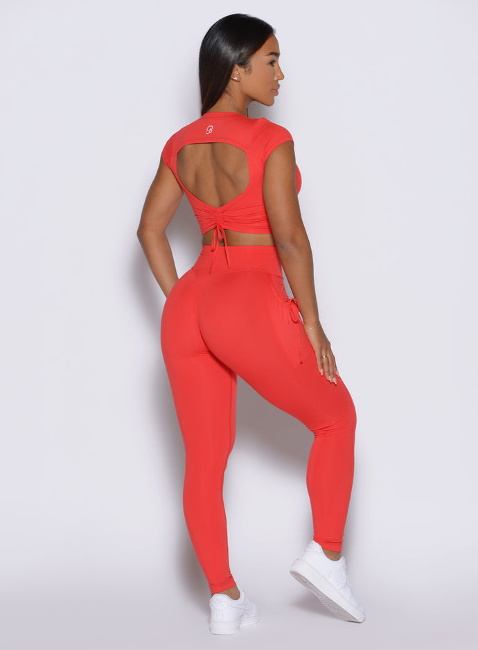 side back profile view of a model wearing the PocketBoost Leggings in Command red color