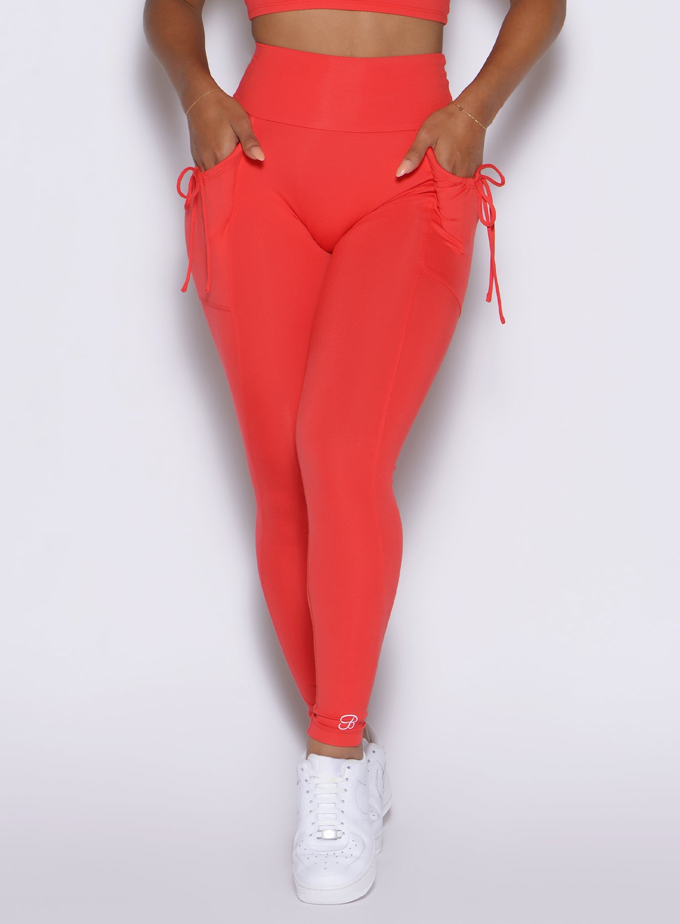 close up front view of a model wearing the PocketBoost Leggings in Command red color