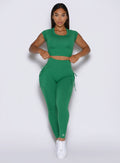 front profile view of a model wearing the PocketBoost Leggings in Field Green color