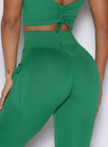 zoomed in back profile view of a model wearing the PocketBoost Leggings in Field Green color