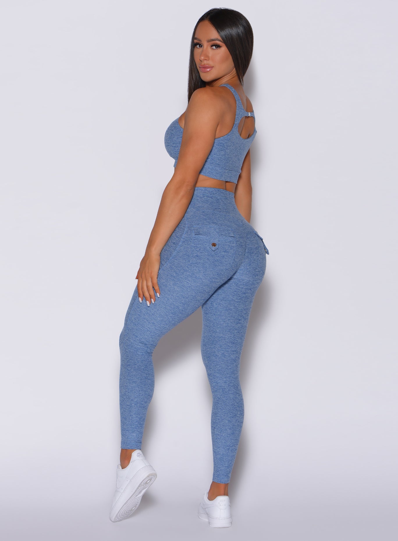 Left side profile view of a model in our Pocket Pop Leggings in sky blue color and a matching sports bra