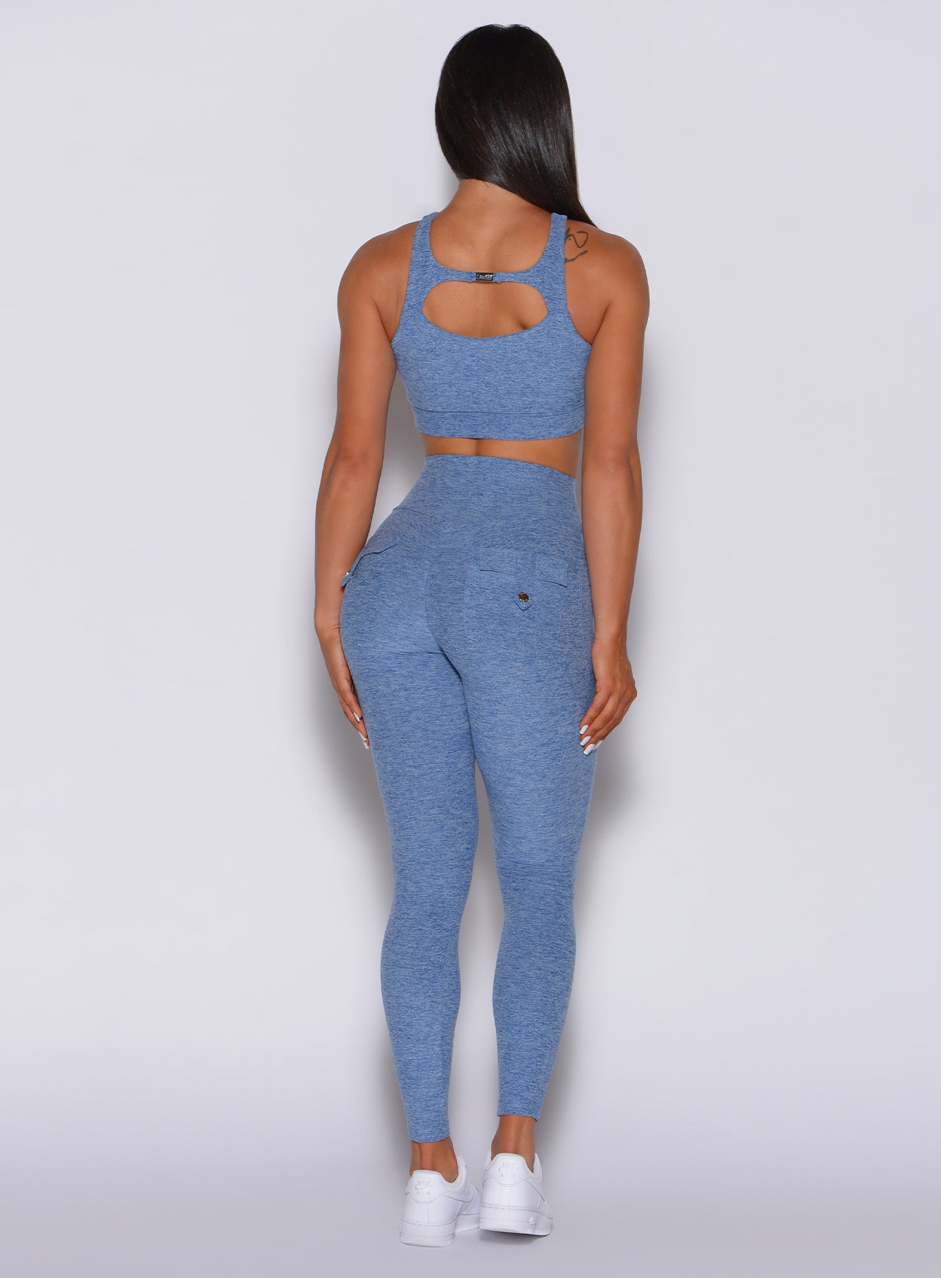 back profile view of a model in our Pocket Pop Leggings in sky blue color and a matching sports bra