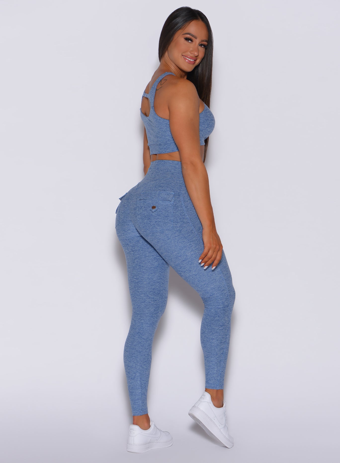 Right profile view of a model in our Pocket Pop Leggings in sky blue color and a matching sports bra