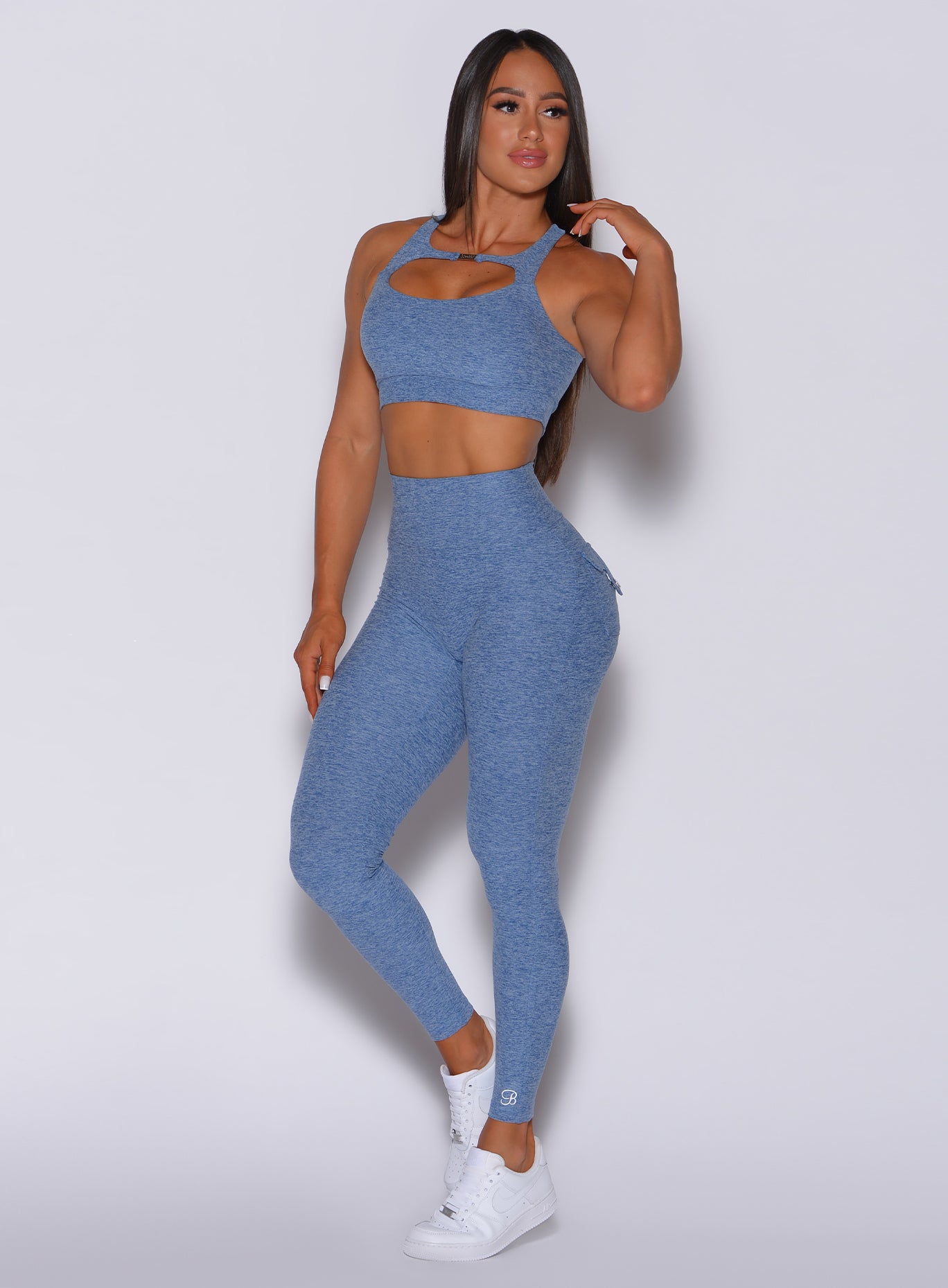 Front profile view of a model wearing our Pocket Pop Leggings in sky blue color and a matching sports bra