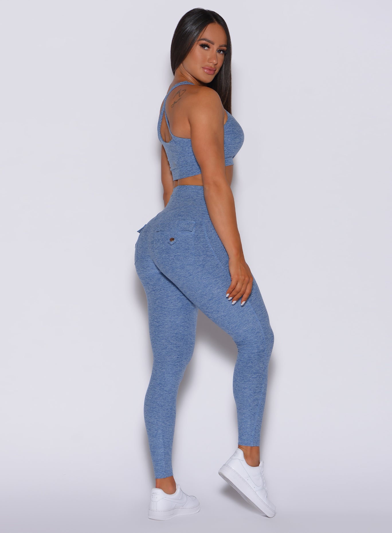 Right profile view of a model in our Pocket Pop Leggings in sky blue color and a matching two way sports bra