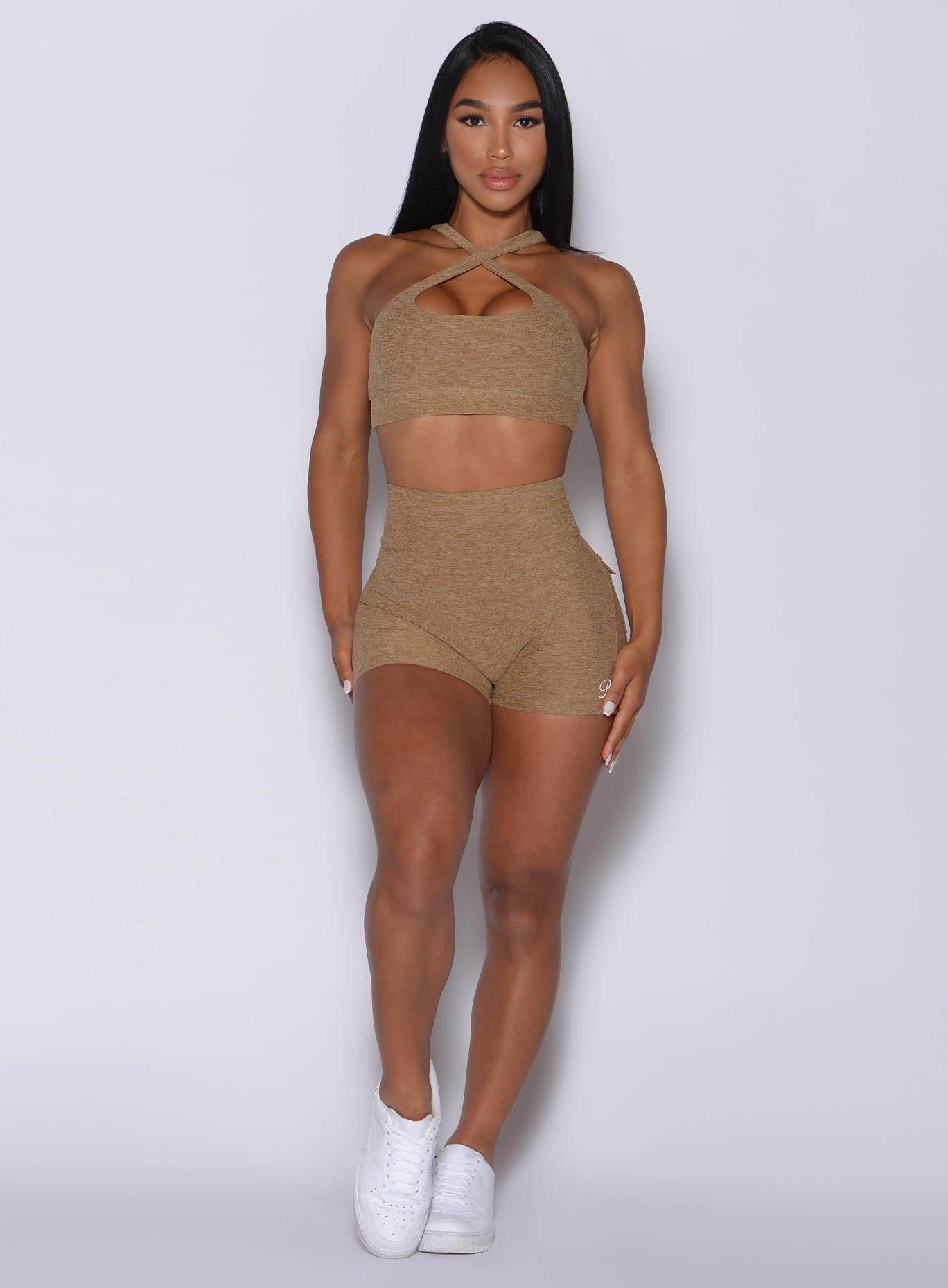 front profile view of a model wearing our Pocket Pop Shorts in caramel color and a matching 2 way sports bra