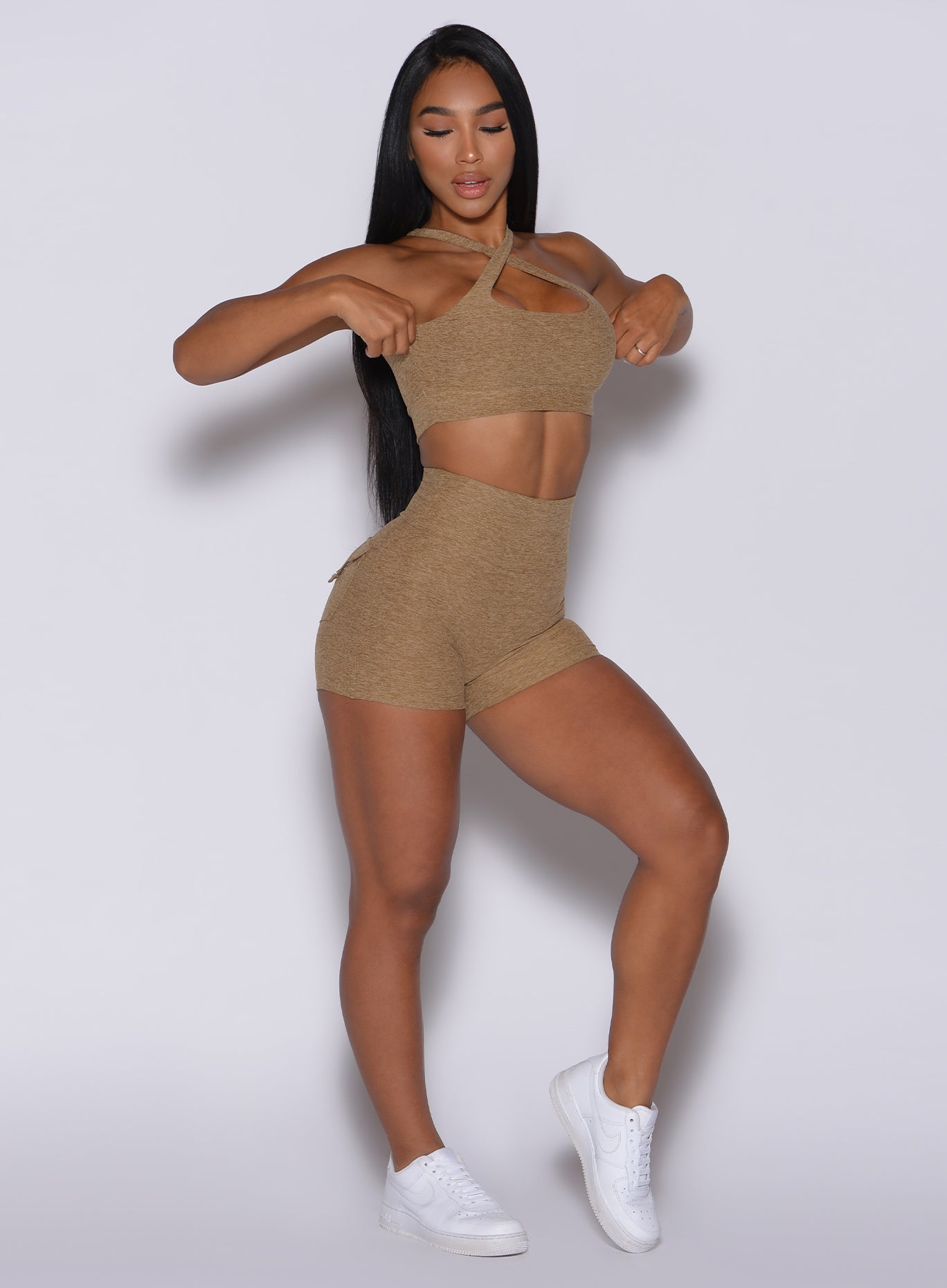 front profile view of a model in our Pocket Pop Shorts in caramel color and a matching two way sports bra