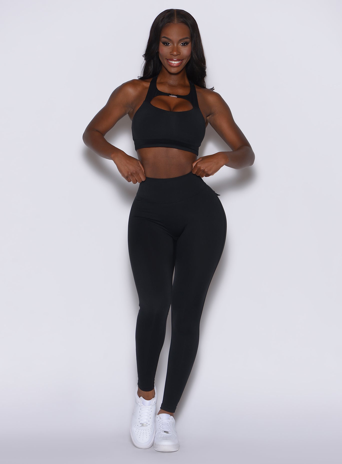 front profile view of a model wearing our black pocket pop leggings along with the matching bra 
