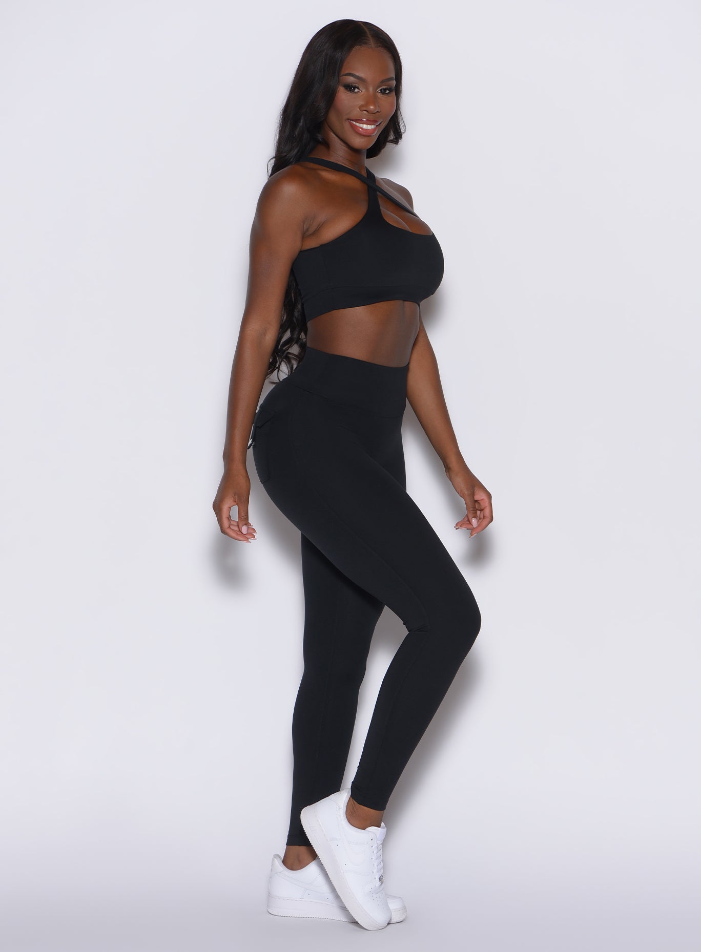 right side profile view of a model wearing our black pocket pop leggings along with the matching bombshell sports bra