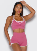 front profile view of a model wearing the Power Line Bra in empowered pink color paired with the matching shorts