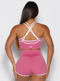 back profile view of a model wearing the Power Line Bra in empowered pink color