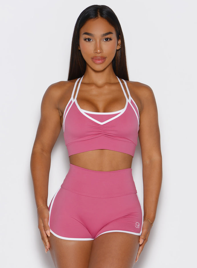 frontal view of a model wearing the power line bra in empowered pink color paired with the matching shorts 