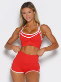 front profile view of a model wearing the Power Line Bra in power red color paired with the matching shorts
