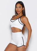 front left side view of a model wearing the Power Line Bra in white color paired with the matching shorts 