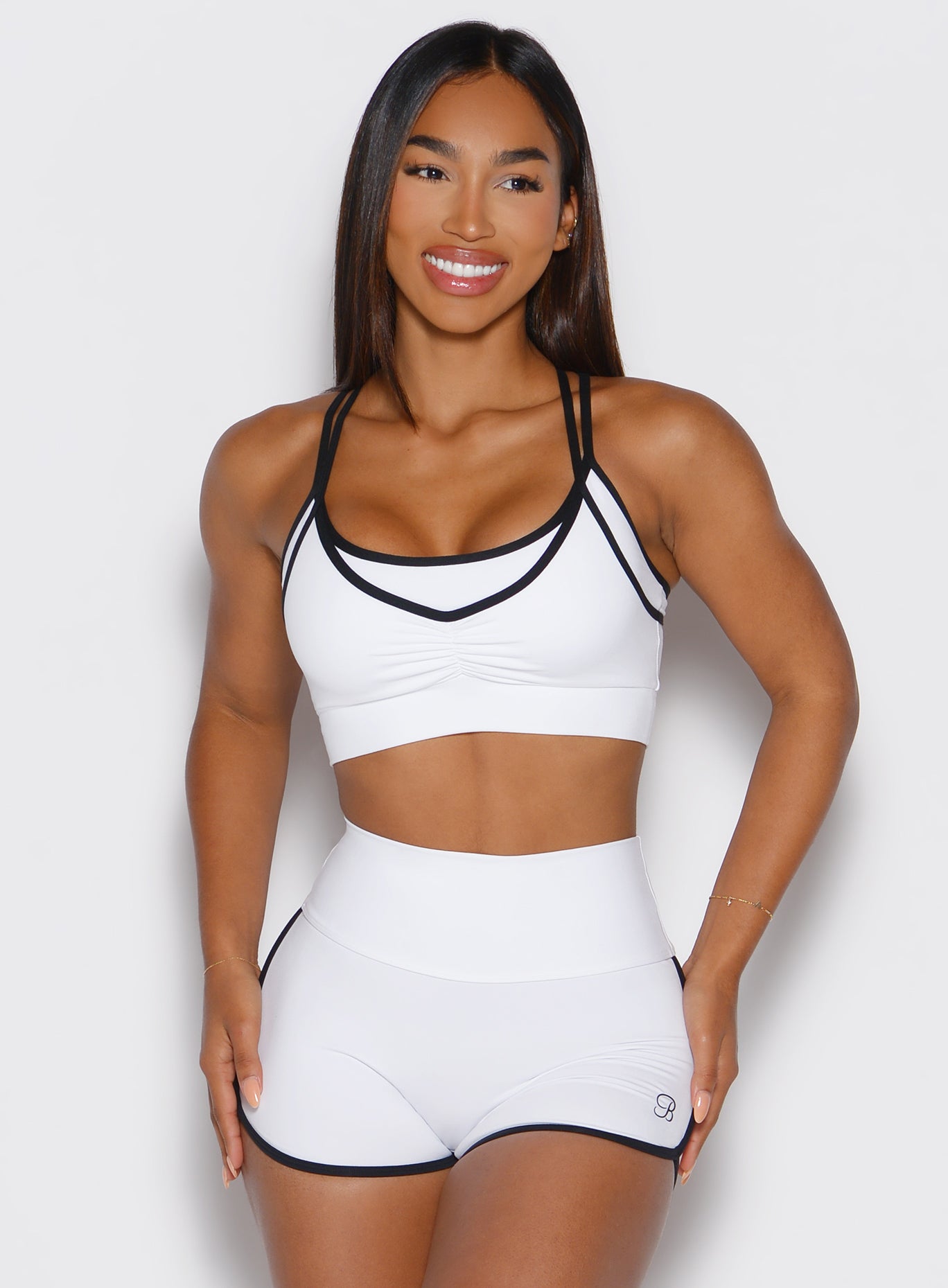 front view of a model wearing the Power Line Bra in white color paired with the matching shorts
