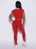 Rear view of sunset red Power Play leggings, highlighting an internal scrunch seam that lifts