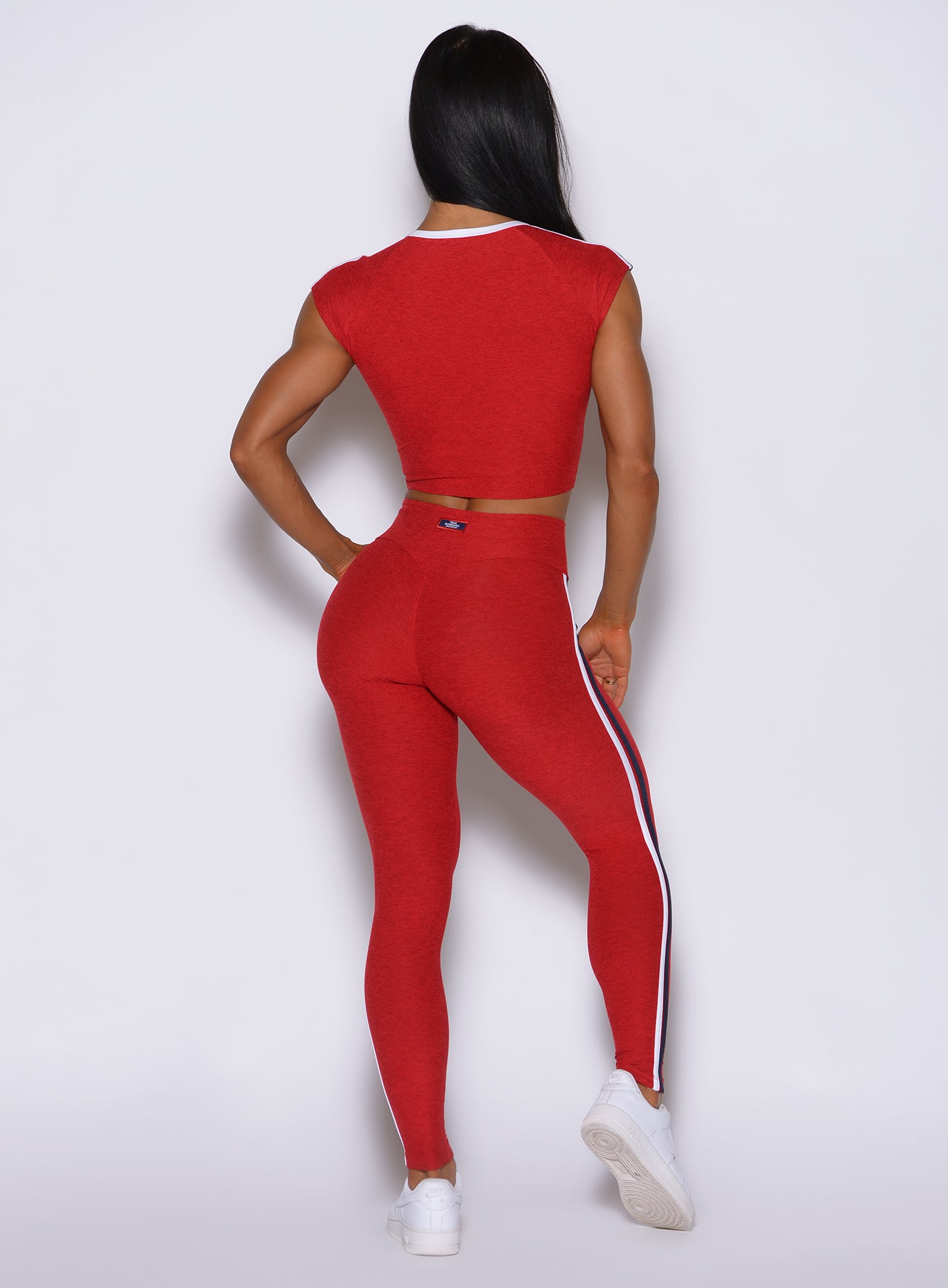 Rear view of sunset red Power Play leggings, highlighting an internal scrunch seam that lifts