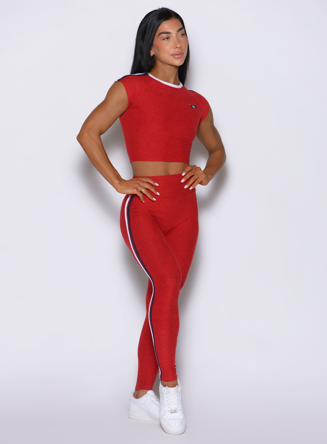 Front-right profile of Power Play leggings in sunset red, capturing the smooth transition of the high waist