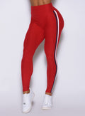 Detailed close-up of the double stripe side binding on the sunset red Power Play leggings.