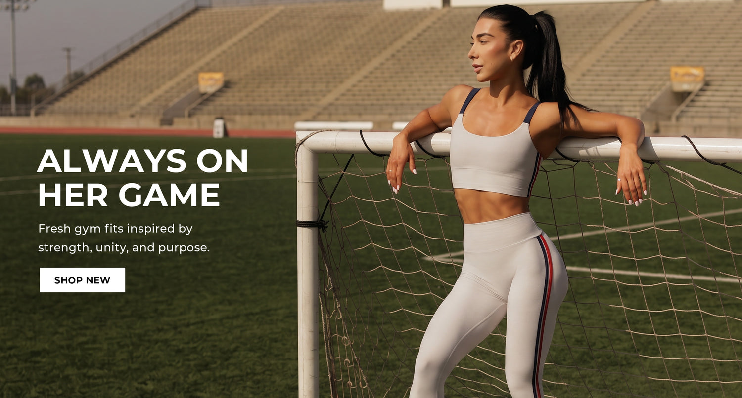 Woman posing in Power Play Leggings and matching United Tank in color Ice standing on a sports field with promotional text overlay. Text says ALWAYS ON HER GAME Fresh gym fits inspired by strength, unity, and purpose. SHOP NEW