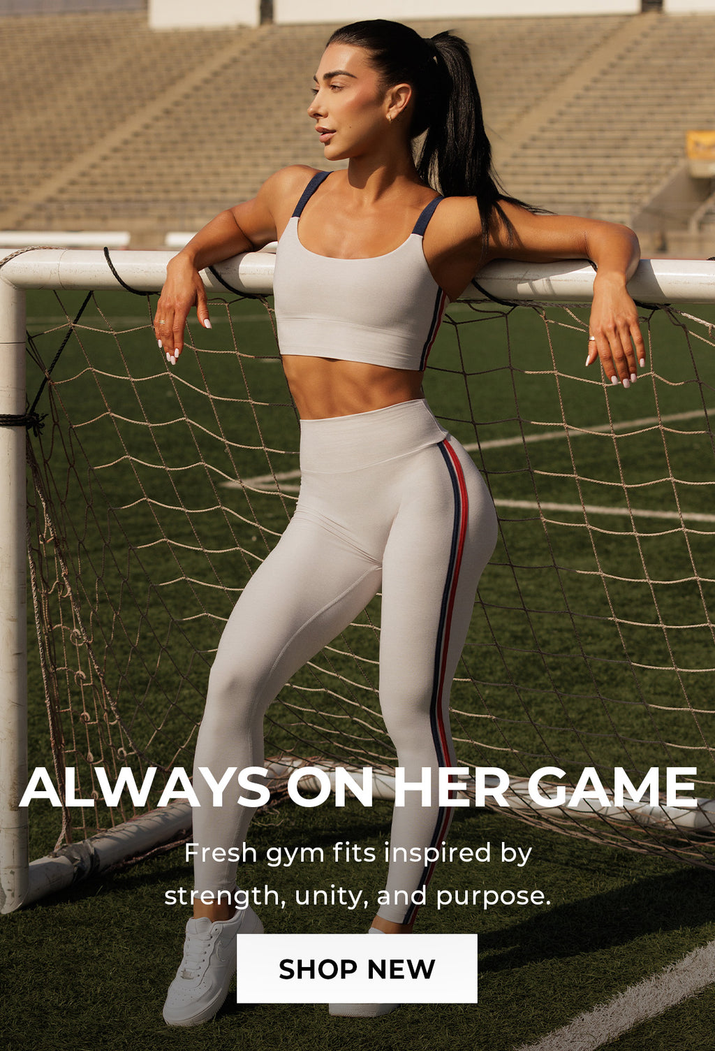 Woman posing in Power Play Leggings and matching United Tank in color Ice standing on a sports field with promotional text overlay. Text says ALWAYS ON HER GAME Fresh gym fits inspired by strength, unity, and purpose. SHOP NEW